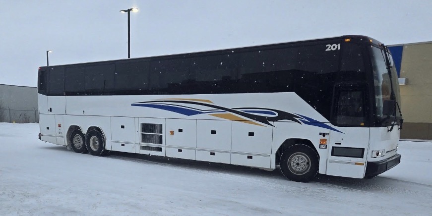 Broston Charters coach 201 parked in a snow-covered lot on a winter day